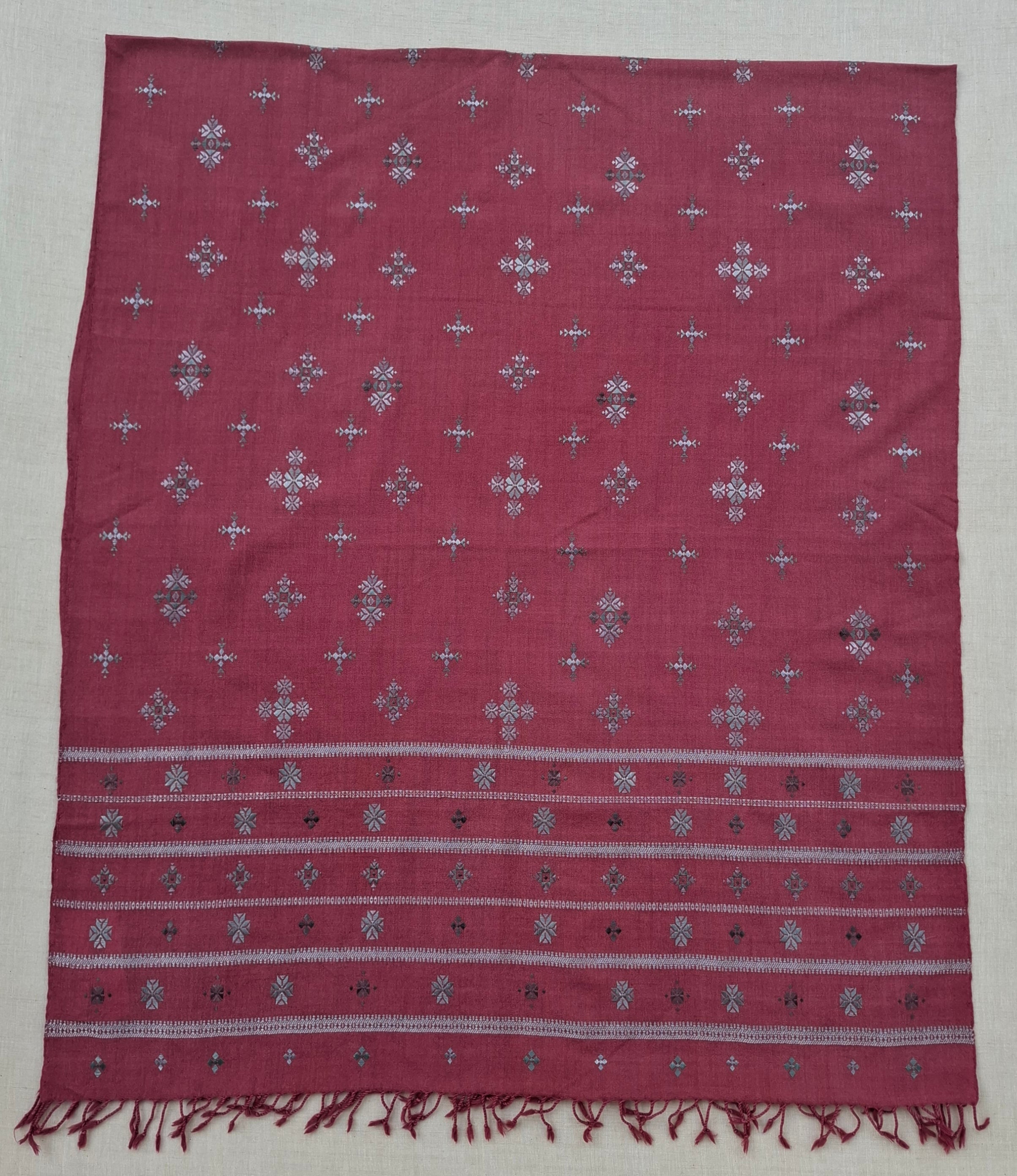 Red patterned fabric with white border on a wooden surface